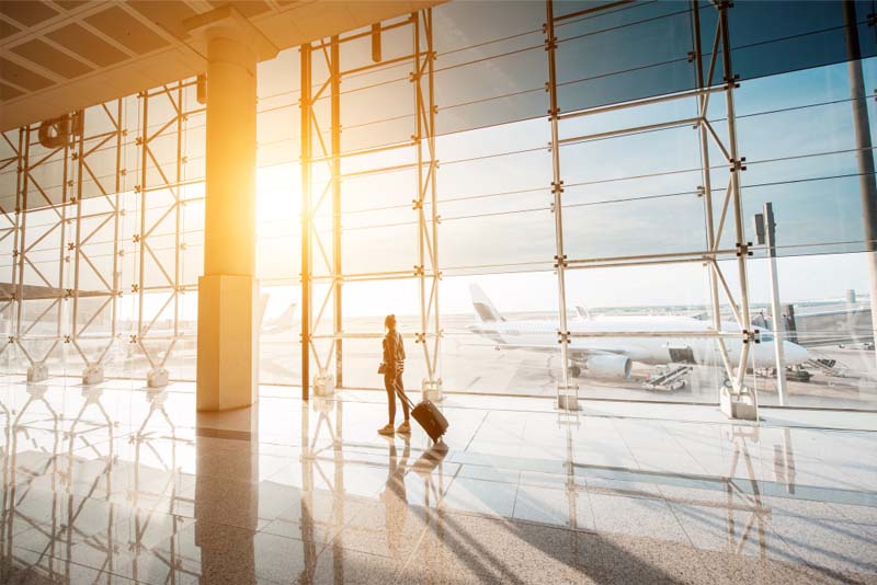 female traveler pulling her suitcase through the airport terminal