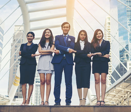 Group of happy young business people holding hands